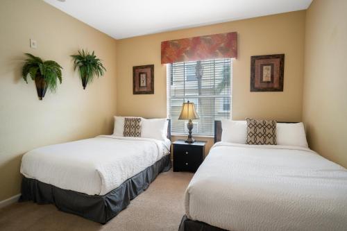 オーランドにあるBeautiful Condo at Vista Cay Resort Near WDWのベッド2台と窓のある寝室