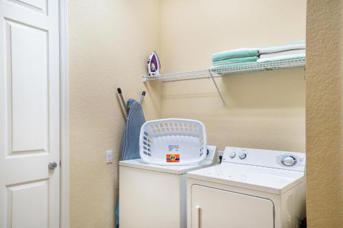 a laundry room with a washing machine and a washer at Beautiful Condo at Vista Cay Resort Near WDW in Orlando