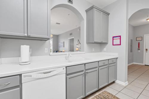 een keuken met witte kasten en een wastafel bij Penthouse Paradise in Orlando