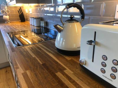 a white tea kettle sitting on a kitchen counter at Edinburgh Street Home - Beautiful House with Free Parking and Wifi, Equipped with comfy furnitures in Swindon