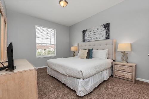 een slaapkamer met een bed en een flatscreen-tv bij Penthouse Paradise in Orlando