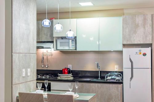 a kitchen with a refrigerator and a table with chairs at Vista do Vale! 400 metros da Rua Coberta - Acomoda até 4 hóspedes in Gramado