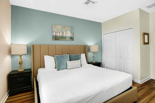 a bedroom with a large white bed with blue walls at Spacious Townhome wPatio Garage Sleeps10 in Orlando