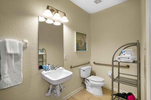 a bathroom with a sink and a toilet and a mirror at Spacious Townhome wPatio Garage Sleeps10 in Orlando