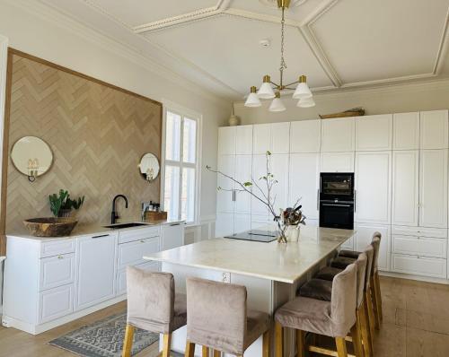 a kitchen with a large white kitchen island with chairs at Room in exclusive villa in sentral Oslo in Oslo