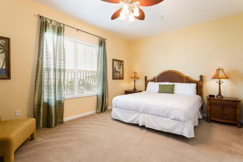 a bedroom with a white bed and a window at Florida Palms in Orlando