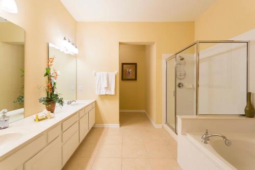 a large bathroom with two sinks and a shower at Florida Palms in Orlando