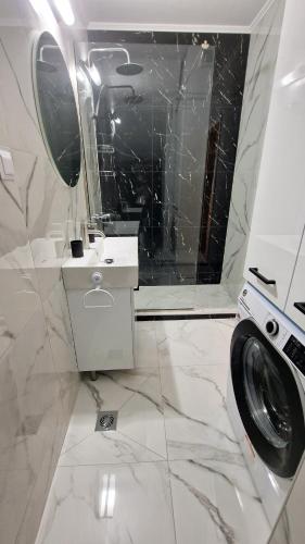 a white bathroom with a washing machine and a mirror at PG Luxury Apartment in Kavála
