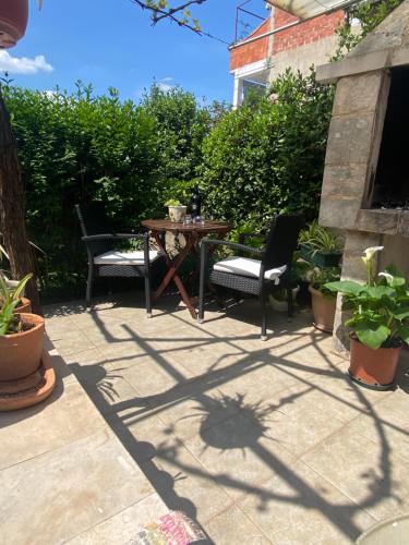 a patio with two chairs and a table and some plants at Villa Volga in Jelsa