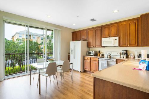 a kitchen with wooden cabinets and a table with chairs at 3-Story Townhome at Vista Cay Resort in Orlando
