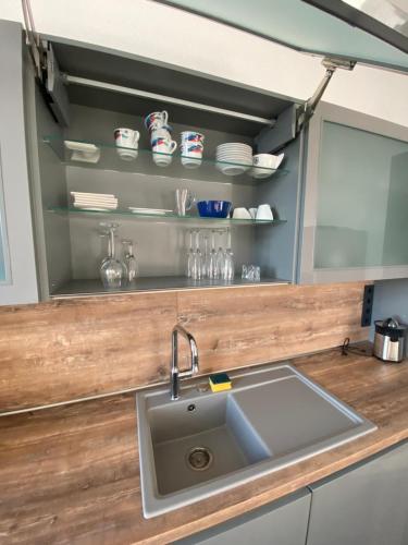 a kitchen counter with a sink and shelves at feelgood Apartments - Apartment Esclusivo - wohnen auf Zeit möblierte Wohnung in Braunschweig