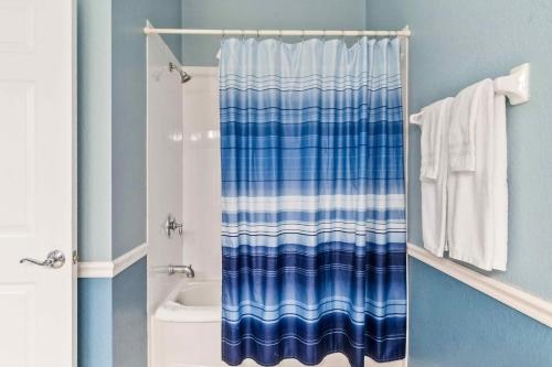 - un rideau de douche bleu et blanc dans la salle de bains dans l'établissement Modern Vista Cay Condo, near Universal Studios, à Orlando