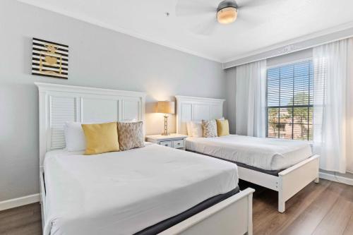 - 2 lits blancs dans une chambre avec fenêtre dans l'établissement Modern Vista Cay Condo, near Universal Studios, à Orlando