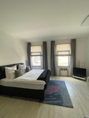 Schlafzimmer mit einem Bett mit einem Teppich und Fenstern in der Unterkunft feelgood Apartments - Apartment Esclusivo - wohnen auf Zeit möblierte Wohnung in Braunschweig