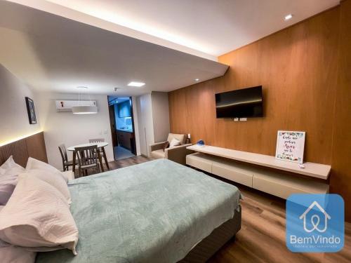 a bedroom with a bed and a tv and a table at Apartamento completo com píer e acesso ao mar 4 in Salvador