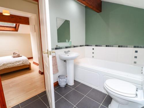 a bathroom with a toilet and a sink and a bath tub at Amberleigh in Oakham