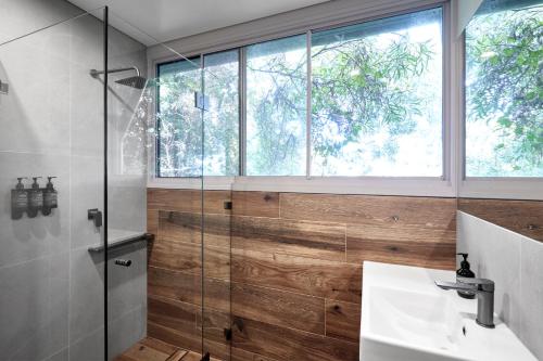 a bathroom with a glass shower and a sink at Roar And Snore in Sydney