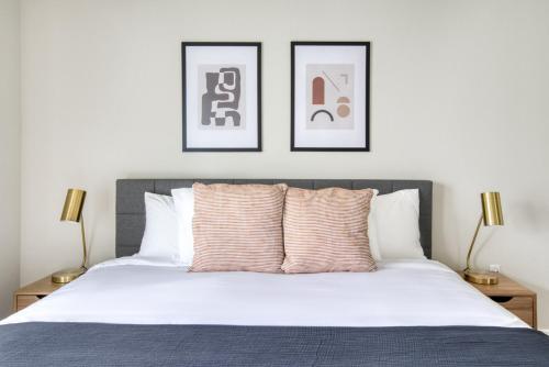 a bedroom with a white bed with three pictures on the wall at Santa Clara 1BR w WD Gym SFO-835 in Santa Clara