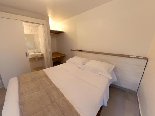 Pousada BRAWAY في كوريتيبا: غرفة نوم بسرير ابيض في غرفة