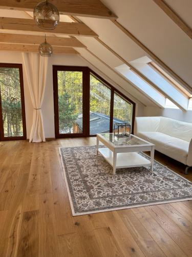 a living room with a white couch and a table at Leśna Residence & SPA in Pisz