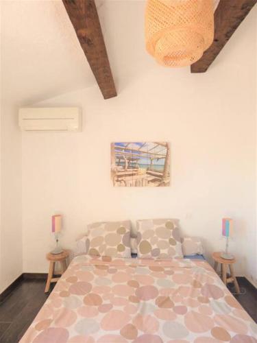 - une chambre avec un grand lit et 2 tables dans l'établissement L'Oasis, villa au calme, 400m plage à pied, à Saint-Aygulf