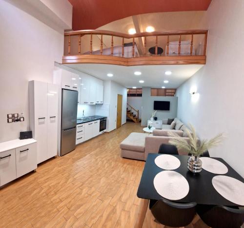 sala de estar amplia con sofá y cocina en PG Luxury Apartment, en Kavala