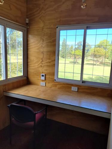 a bench in a room with two windows at Casa Mojada in Rosario