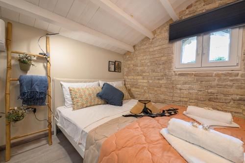 a bedroom with a bed and a brick wall at Casa Iolanda II in Corfu
