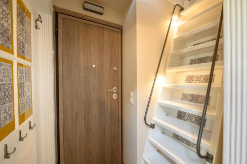 a walk in closet with a wooden door and shelves at Casa Iolanda II in Corfu