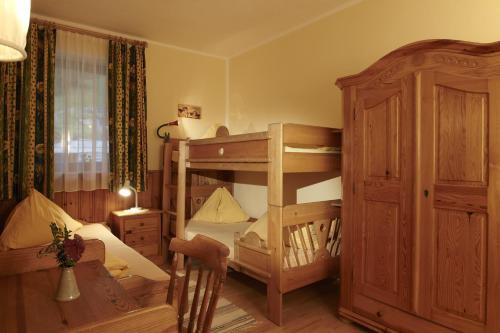 a bedroom with a bunk bed and a bed and a room with a bunk bed at Biolandhaus Arche in Eberstein