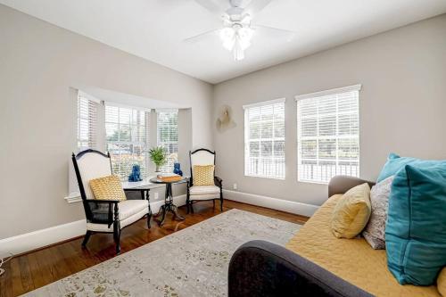 a living room with a couch and a table and windows at The Eagles Retreat in Houston
