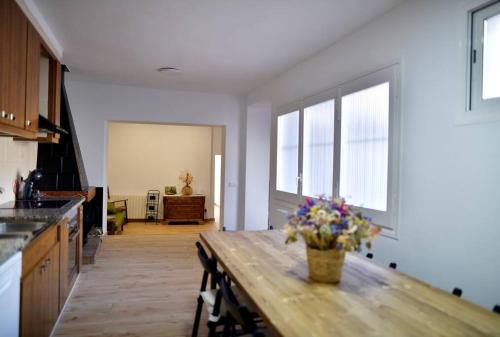 una cocina con una mesa de madera con flores. en Can Mosqueroles casa en Castellfollit de la Roca, en Girona