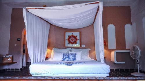 a bed with a canopy in a bedroom at Baxar in Pie de la Cuesta