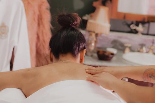 a woman getting a massage in a bath tub at Hotel Boutique Quinta das Videiras in Florianópolis