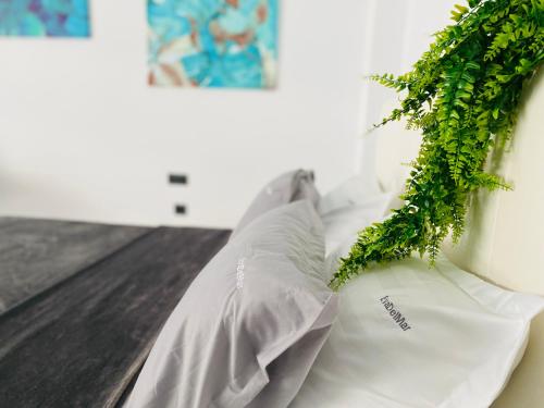 un cuscino bianco con una foglia verde su un letto di Eva Del Mar - Sea view - Mamaia Nord a Mamaia