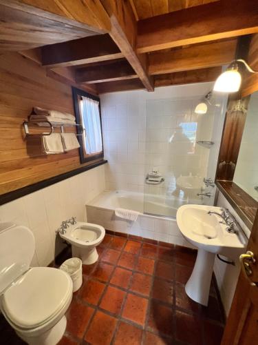 a bathroom with two toilets and a sink and a tub at Apartamentos céntricos en San Martin de los Andes. in San Martín de los Andes