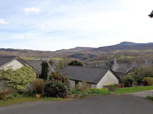 a village with houses and mountains in the background at Staylittle Farm in Dolgellau
