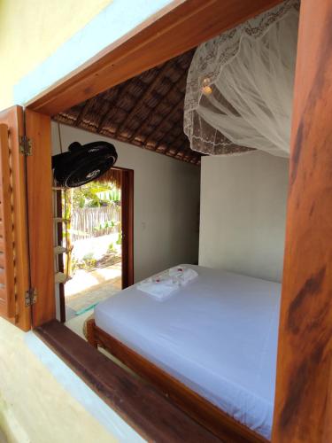 a bed in a room with a window at Pitico Chalé - Icaraí Kite Village in Icaraí