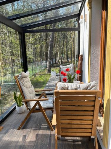 a screened in porch with a couch and a chair at Leśna Residence & SPA in Pisz