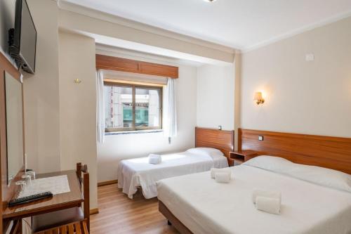 a hotel room with two beds and a window at Santa Barbara by Umbral in Fátima