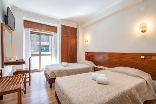 a hotel room with two beds and a window at Santa Barbara by Umbral in Fátima