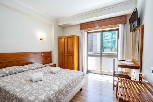 a bedroom with a bed and a large window at Santa Barbara by Umbral in Fátima