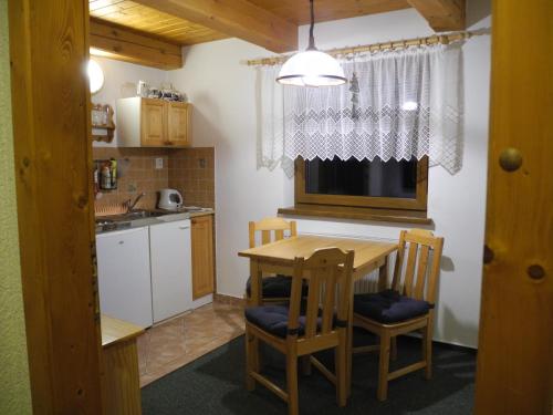 a kitchen with a table and chairs and a sink at Apartmány Müller in Bedřichov