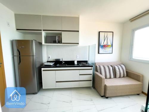 a kitchen with a sink and a refrigerator and a chair at Studio Completo a 150m da Praia de Piatã 2 in Salvador