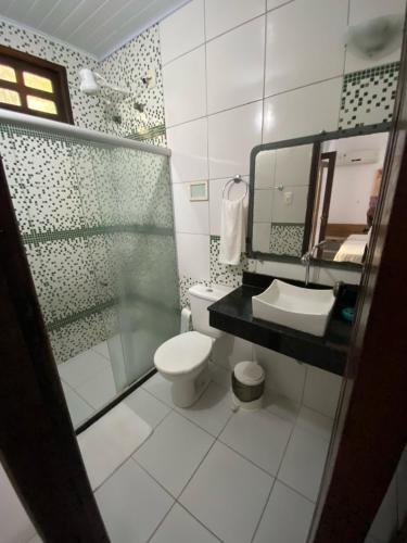 La salle de bains est pourvue de toilettes, d'un lavabo et d'un miroir. dans l'établissement Pousada Maramar/terceira praia MSP, à Morro de São Paulo