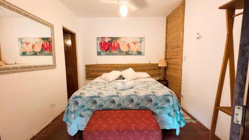 a bedroom with a bed with a red ottoman at Villa Adria in Ilhabela