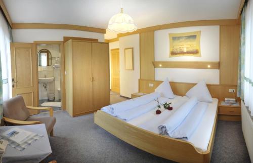 1 dormitorio grande con 1 cama grande con sábanas blancas en Alpenbad, en Ramsau am Dachstein