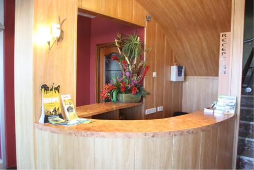 eine Theke in einem Zimmer mit einem Spiegel und Blumen in der Unterkunft Hotel Rio Mar in Peñíscola