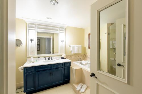 La salle de bains est pourvue d'un lavabo bleu et d'un miroir. dans l'établissement Inn and Club at Harbour Town, à Île de Hilton-Head