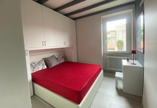 a bedroom with a red bed with a window at Marilyn Apartment in Como